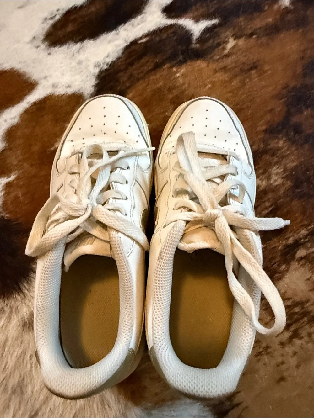 Nike low top Air Force ones. All white with gold swoosh.